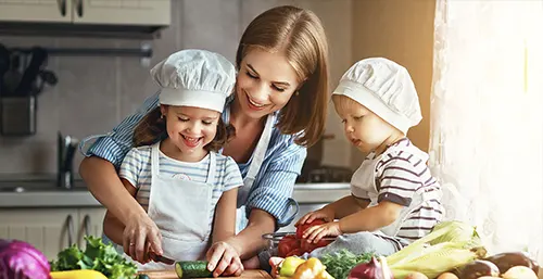Dieta na odporność, zdrowa dieta dla dzieci. Mama gotuje z dziećmi w kuchni.